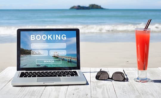 laptop with sun glasses on table on the beach